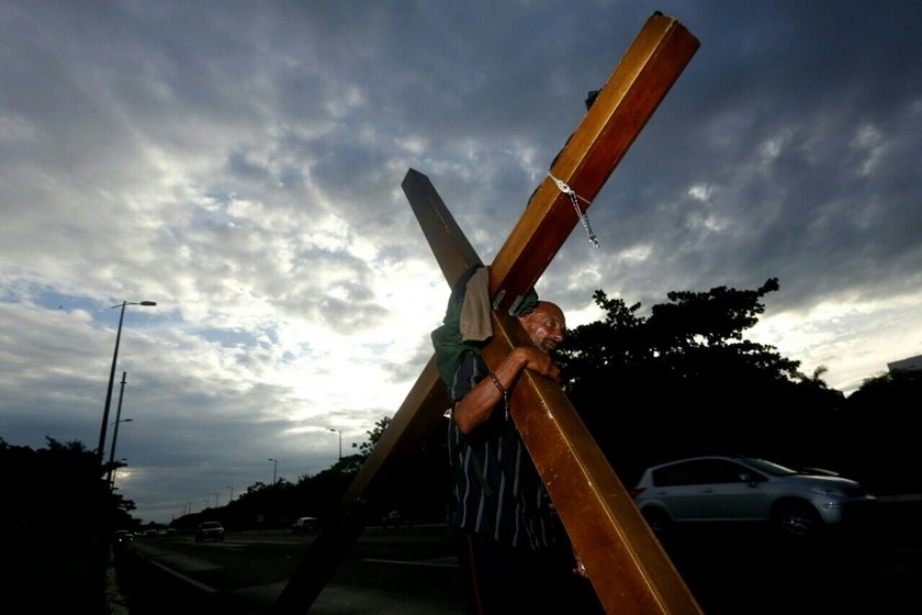 Homem carrega cruz de 40kg no Eixão Sul e chama a atenção de motoristas
