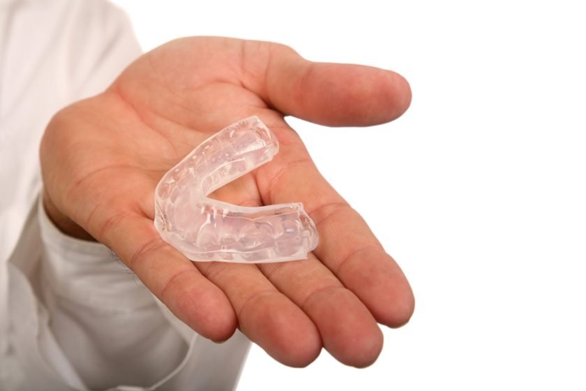 Person holding mouthguard in hand