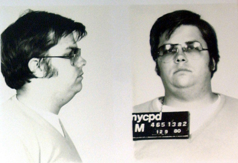 Mark David Chapman, o assassino de John Lennon. Foto em preto e branco de um homem com óculos, cabelo preto e pele clara, de perfil e depois de frente - Metrópoles