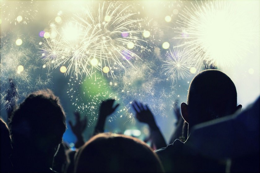 Cheering crowd and fireworks at New Year’s Eve – people celbrating on open air