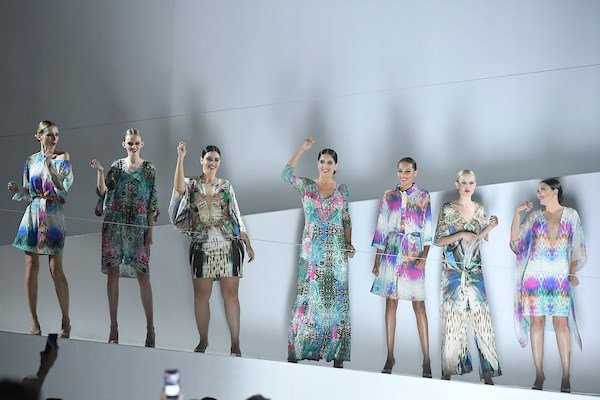 Em fundo branco, modelos usam roupas coloridas em desfile de moda - Metrópoles
