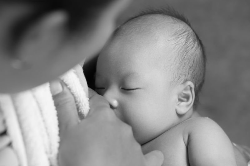 foto preto e branco, mãe amamentando bebê