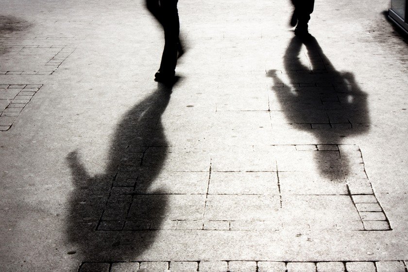 Shadow of two person on pattered sidewalk in black and white
