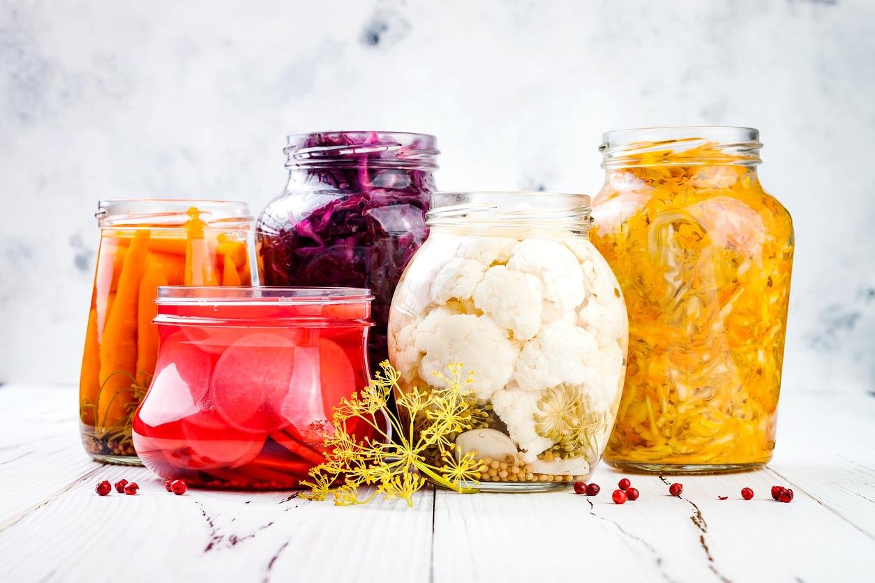 Sauerkraut variety preserving jars. Homemade red cabbage beetroot kraut, turmeric yellow kraut, marinated cauliflower, carrots and radish pickles. Fermented food.