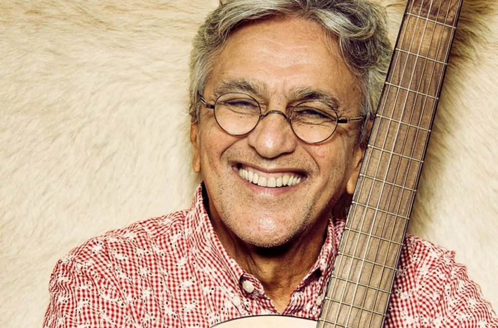 Caetano Veloso sorrindo com violão