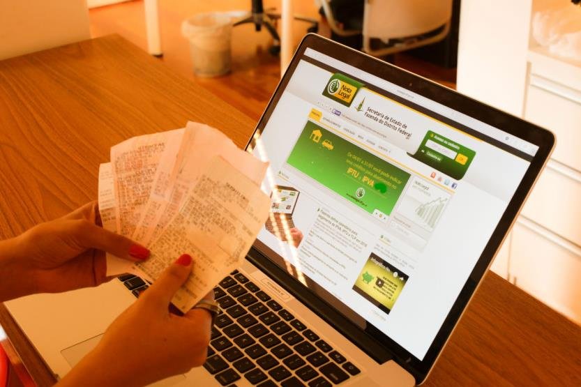 computador e consumidor com notas fiscais