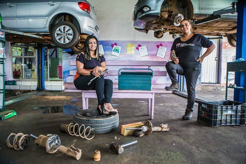 Mulheres mecânicas consertando carro