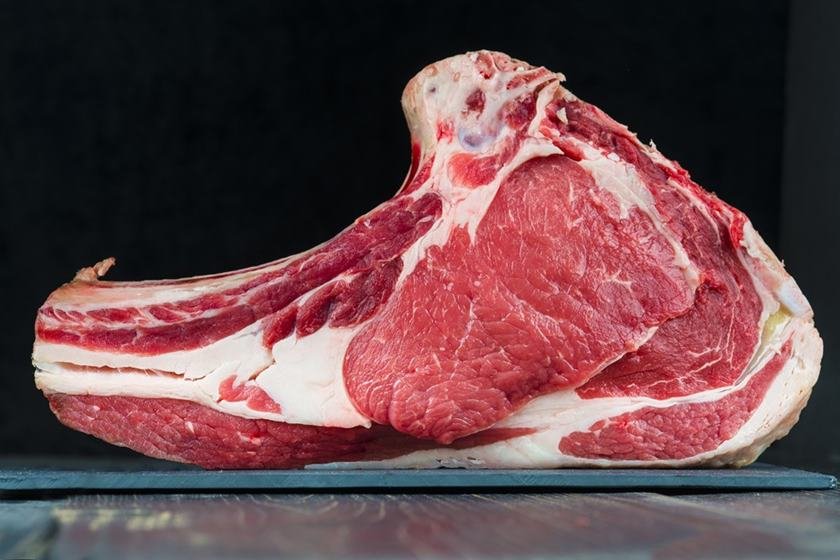 Raw veal T-bone steak on a black background