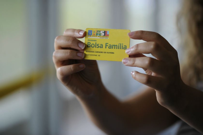 Imagem colorida mostra cartão do programa Bolsa Família nas mãos de uma pessoa - Metrópoles