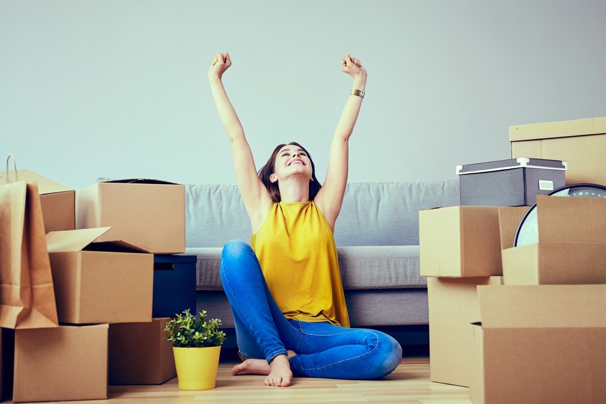 Happy young woman moving to new home – having fun