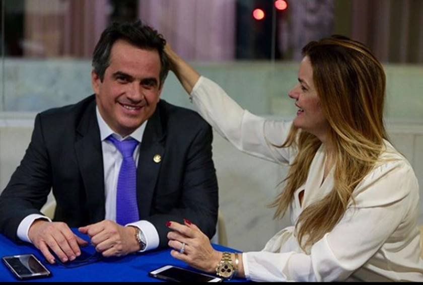 Em ambiento interno, Ciro Nogueira (PP) recebe carinho na cabeça de sua esposa, a deputada federal Iracema Portella (PP). Ambos estão sentados numa mesa azul e com roupas formais - Metrópoles