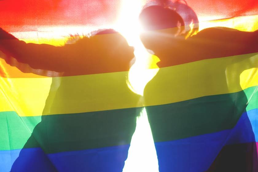Bandeira LGBT com silhueta de duas pessoas atrás
