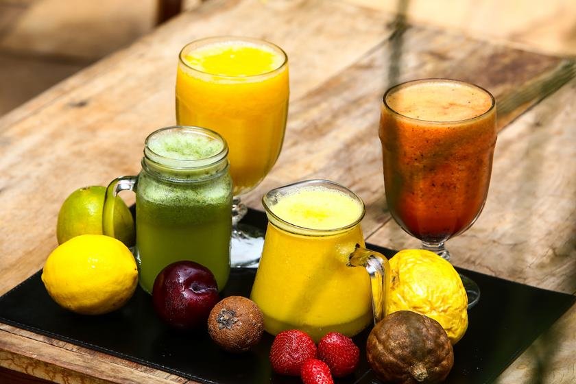 Sucos de frutas, suco verde, suco de laranja em cima da mesa com outras frutas em copos de vidros - Metrópoles