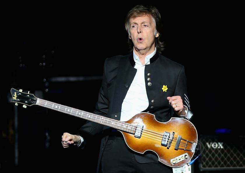Foto colorida de Paul McCartney segurando guitarra durante show - Metrópoles