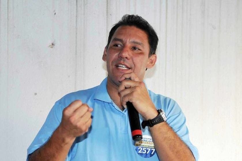 Homem segura microfone com a mão esquerda e fecha punho direito