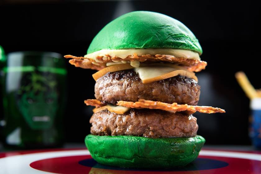 Na foto, um hambúrguer com dois discos de carne e pão verde - Metrópoles