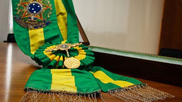 Faixa presidencial. O objeto tem cores verde e amarela e o brasão do Brasil estampado | Metrópoles