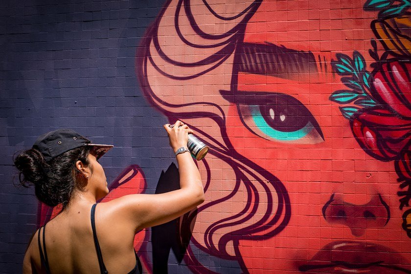 Mulher pinta muro