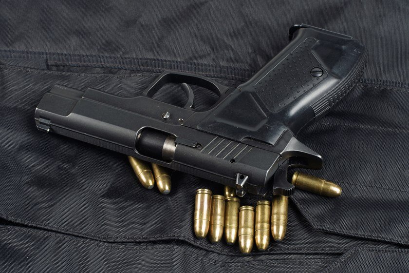 police handgun on black uniform background