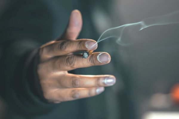 mão segurando cigarro aceso