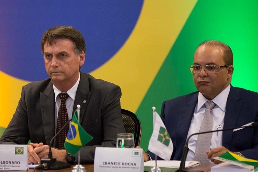 Bolsonaro e Ibaneis sentados na mesma mesa