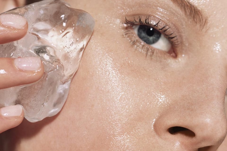 Woman putting ice on her face