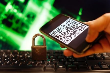 celular com qr code e cadeado sobre teclado