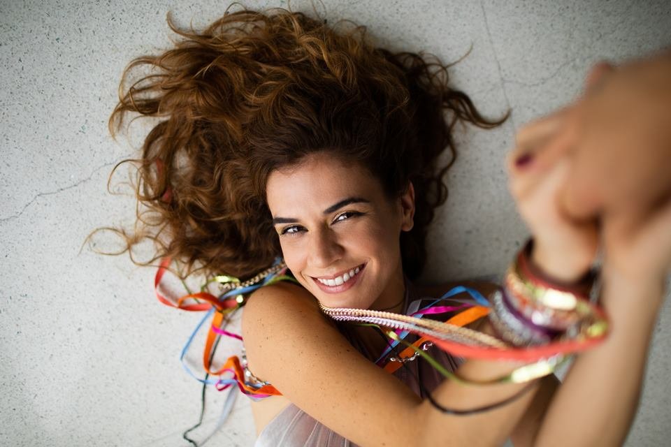 imagem colorida mostra a cantora mariana aydar. ela tem cabelos ondulados, é branca e traz fitas coloridas no braço - metrópoles