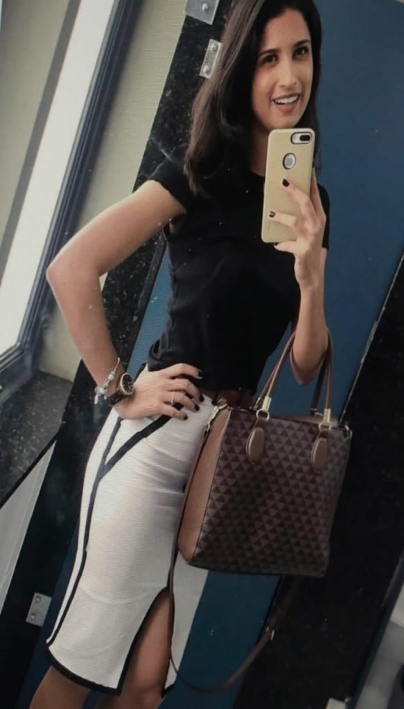 mulher de blusa preta e saia tora selfie