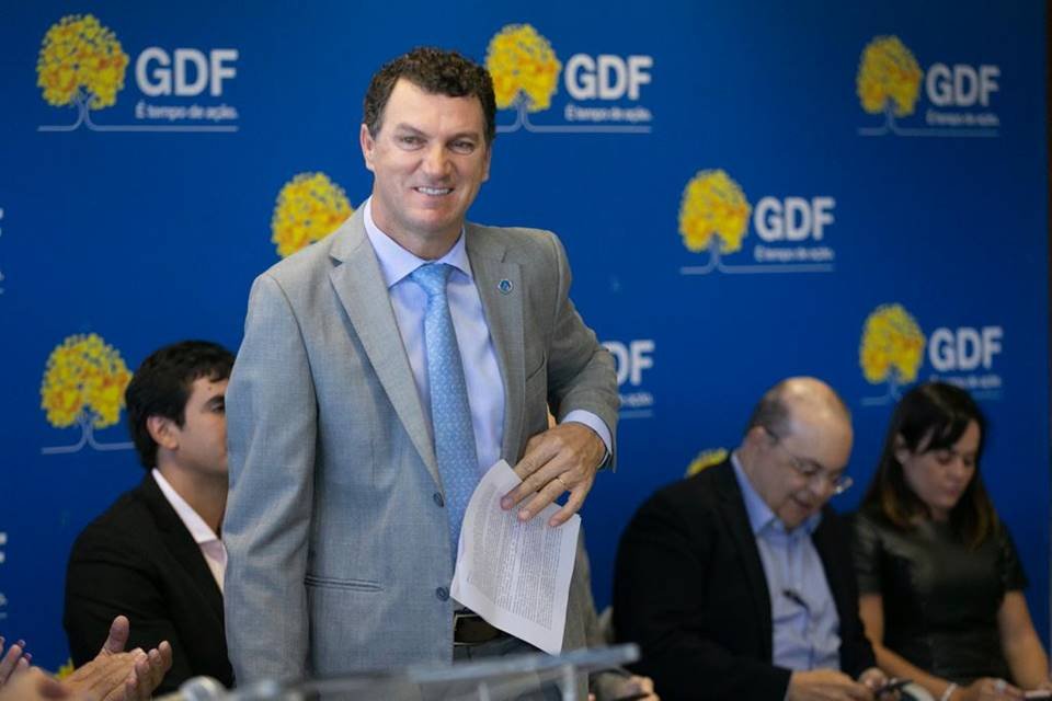 Deputado Iolando Almeida; Ibaneis ao fundo e banner azul do GDF ao fundo