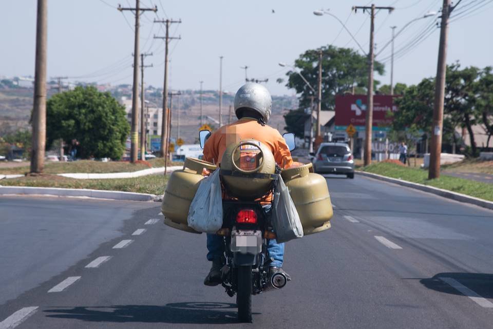 Motociclista levando botijões