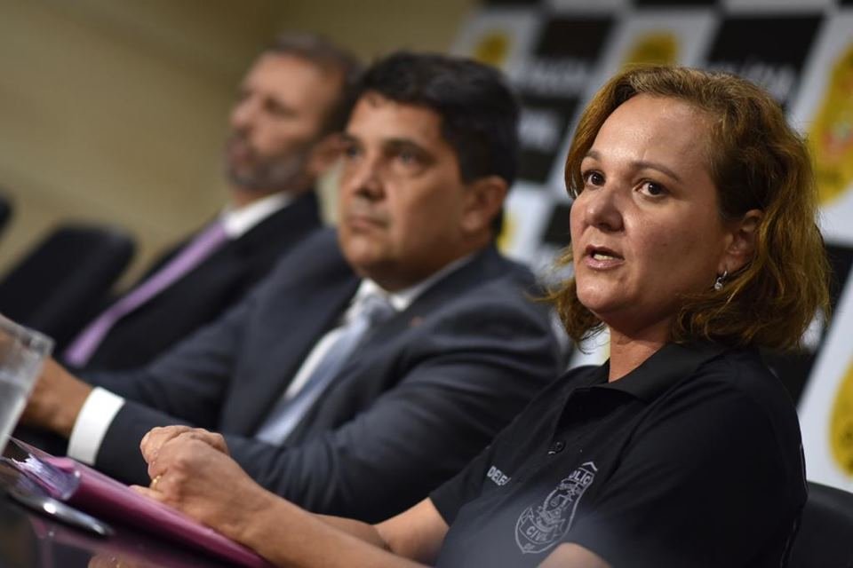 Dois homens de terno e uma mulher de preto