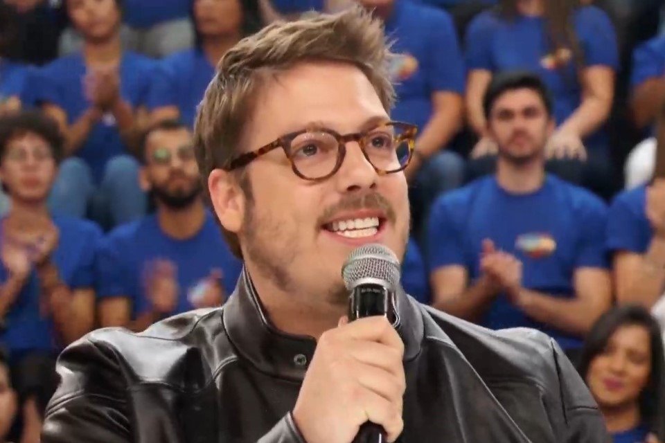 Colorful photo of Fábio Porchat using oculos e com microfone nas mãos - Metropolis