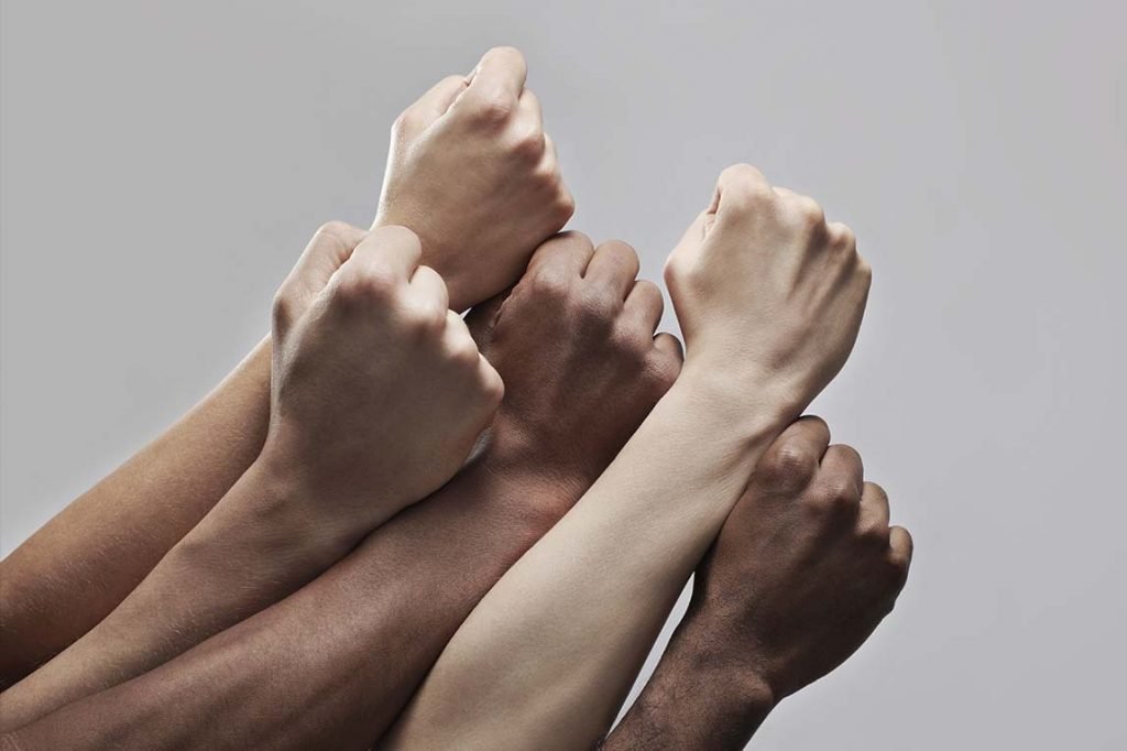 Imagem colorida de punhos cerrados de pessoas pretas, pardas, negras - Metrópoles