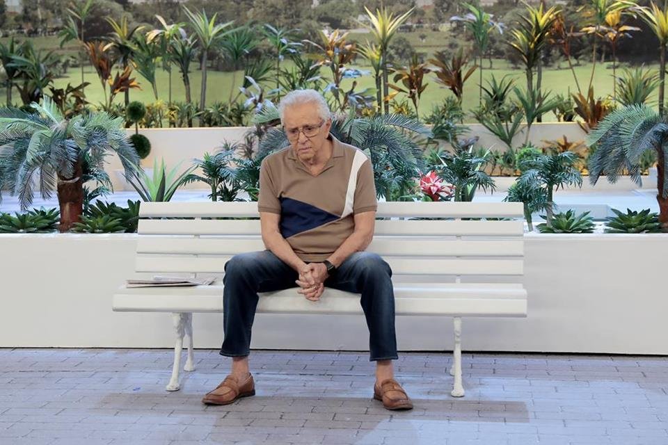 Carlos Alberto sentado triste no banco da Praça é Nossa
