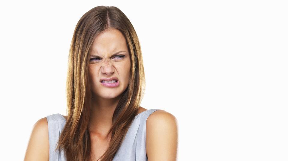 Portrait of disgusted woman standing with hands folded