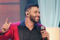 Gusttavo Lima de terno vermelho e cantando