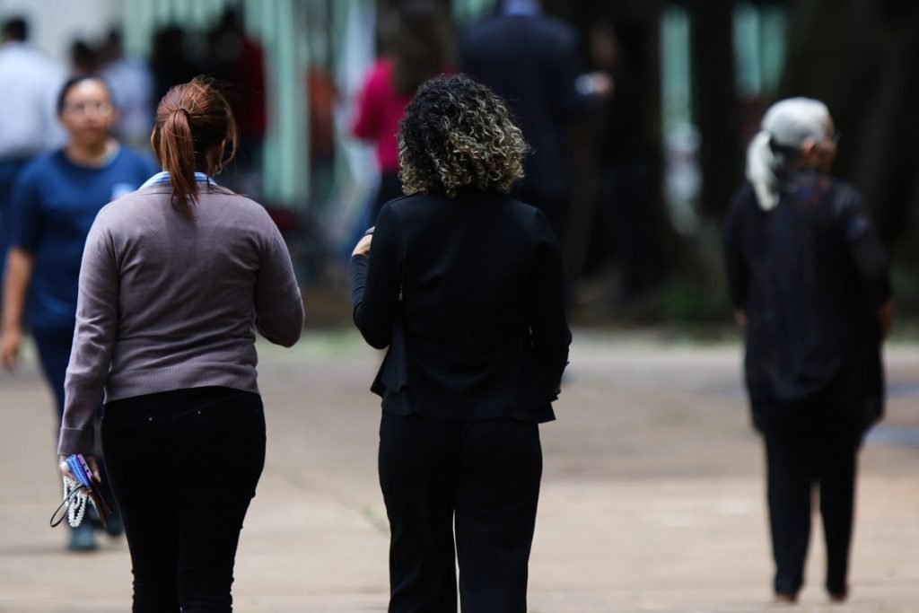 Mulheres de costas andando na rua