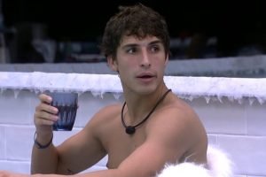 Falipe Prior na cozinha do BBB20 com um copo na mão