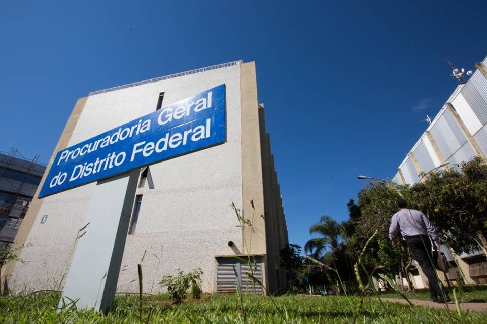 Fotografia colorida de placa azul em frente a edifício