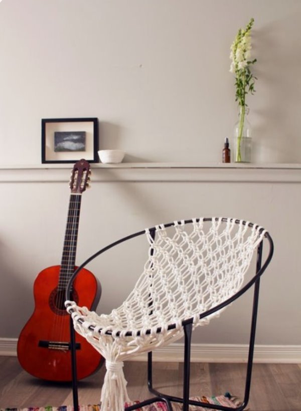 Cadeira de macramê na sala de estar com violão