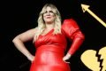 Marília Mendonça de macacão vermelho em show na cidade de São Paulo