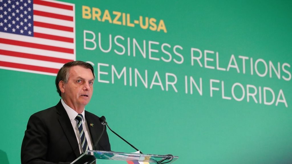 Bolsonaro em seminário com bandeira dos EUA ao fundo