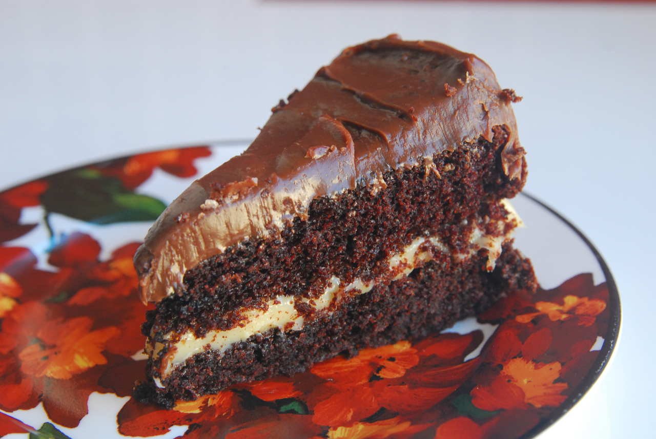 Bolo de chocolate com camadas de chocolate branco em um prato estampado nas cores vermelho e verde