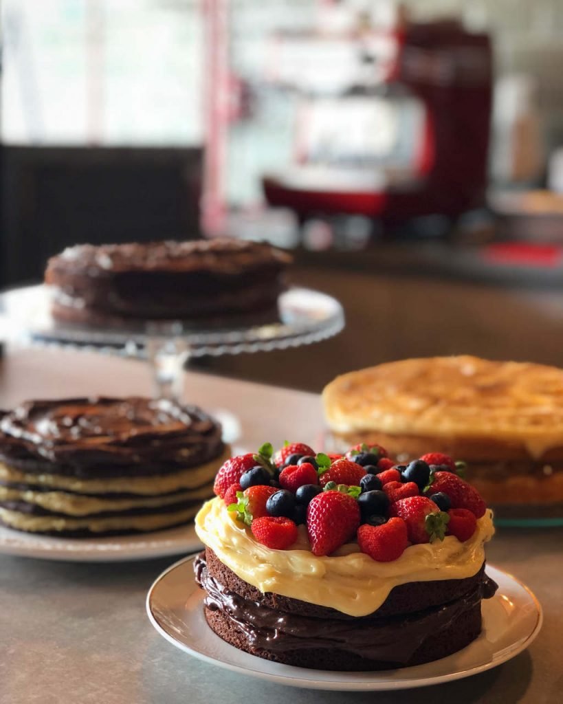 Quatro bolos de diferentes sabores em cima de um balcão