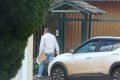 Oficial de Justiça, com máscara, tenta falar com marido de paciente que tem coronavírus