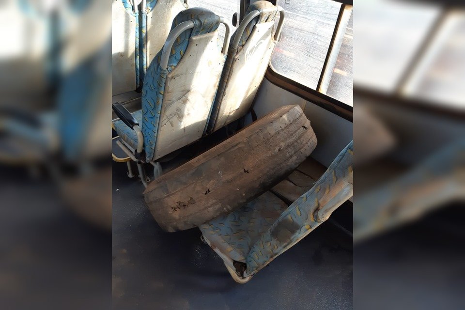 Pneu de ônibus colocado sobre cadeira do coletivo