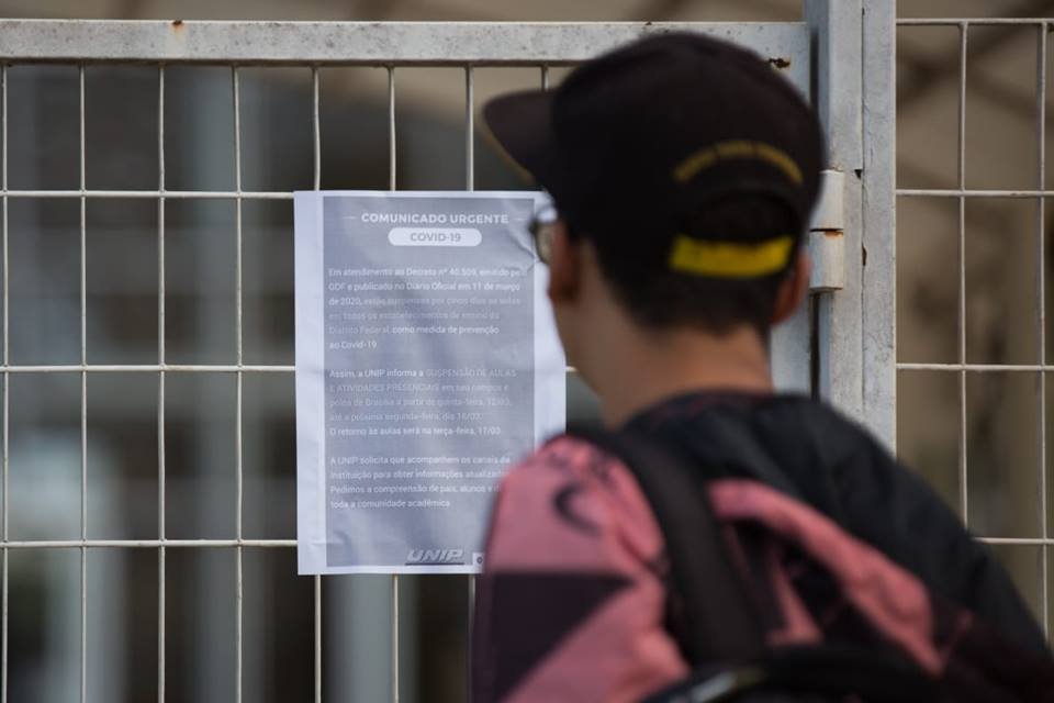 O estudante Marcos Barbosa lê aviso em frente à Unip avisando suspensão de aulas por causa do novo coronavírus