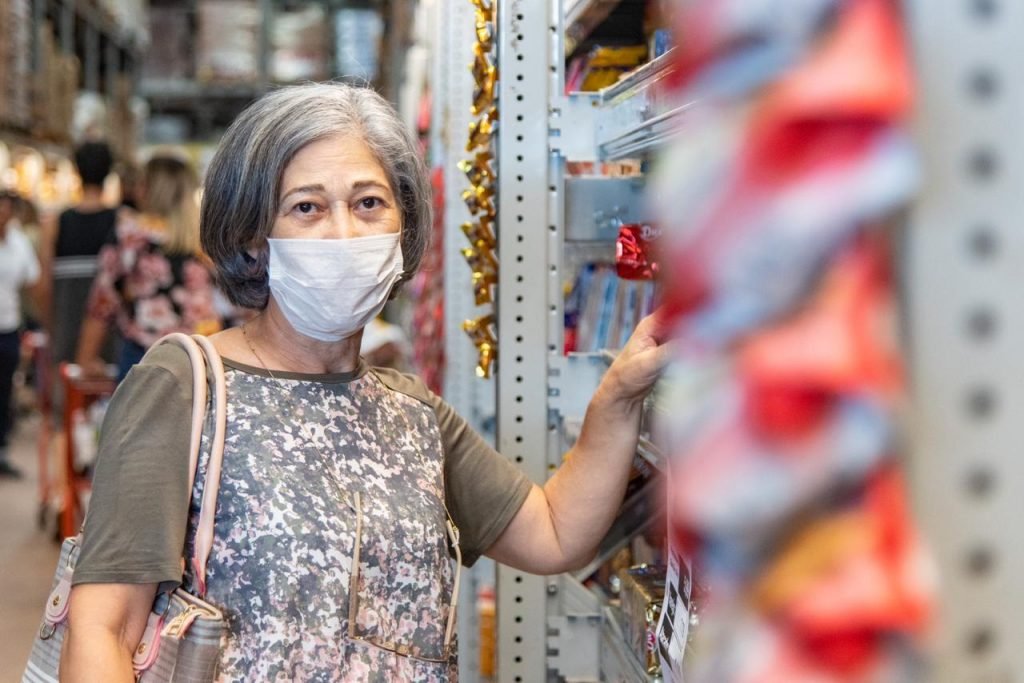 Mulher usa máscara para fazer compras em supermercado