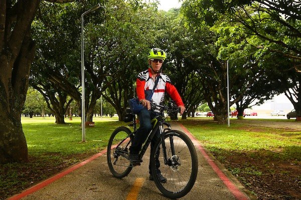 Homem com bicicleta em ciclovia